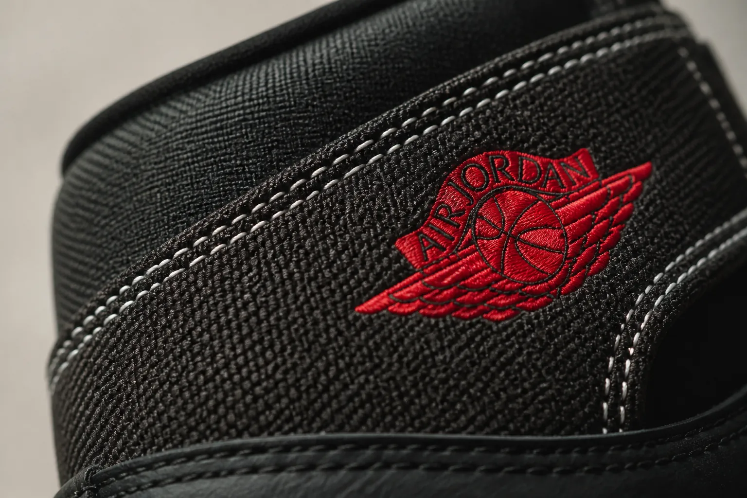 Detailed macro shot of premium black woven textile upper showing intricate weave pattern and texture quality