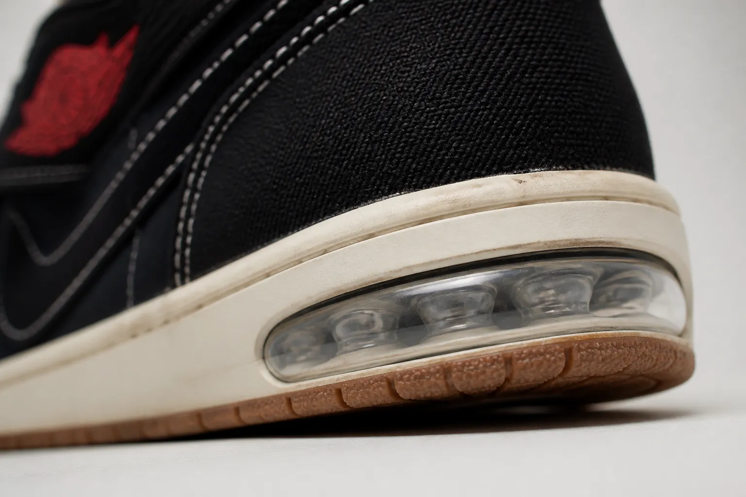 Close-up macro photograph of the Nike Air-Sole unit embedded in the heel of the Air Jordan 1, showcasing the translucent bubble technology that provides superior cushioning and impact absorption with soft bounce-back response