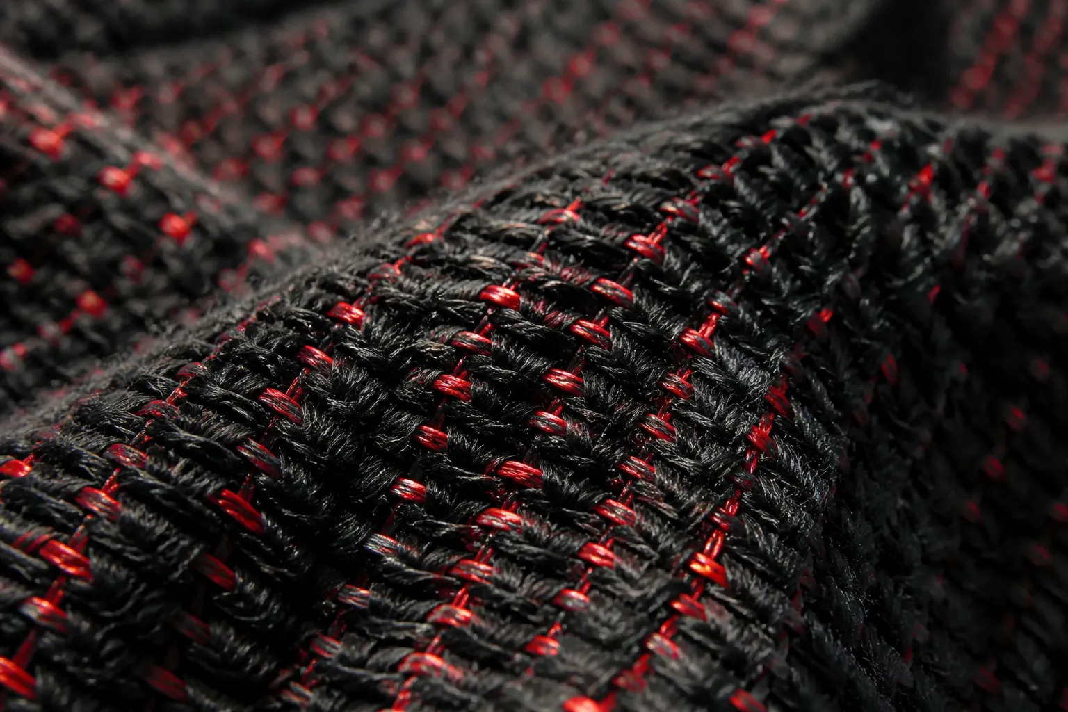 Premium woven textile upper close-up showing intricate weaving pattern in black with red thread accents