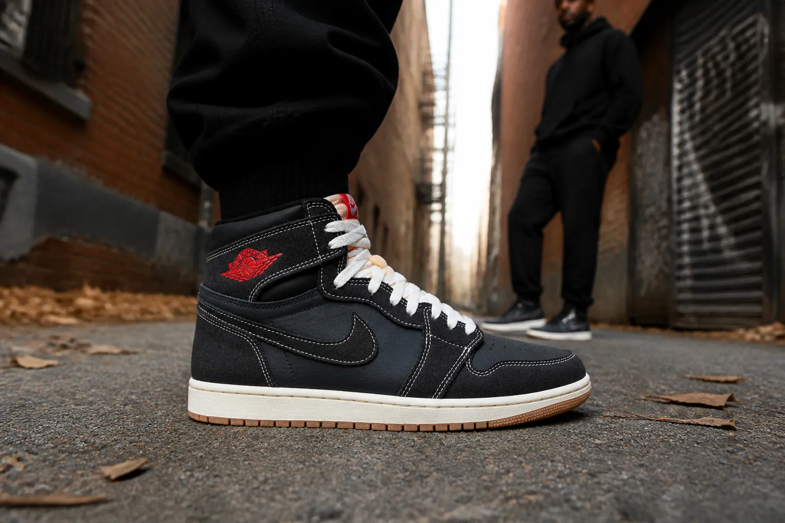 Fashion-forward individual styled in all-black streetwear posing with Air Jordan 1 Flight Club in an urban alleyway setting