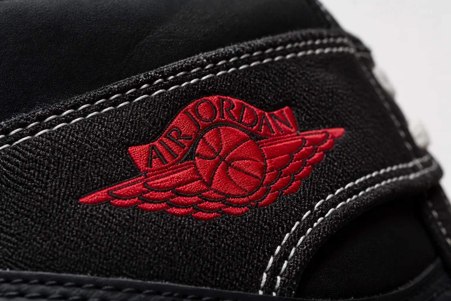 Vibrant close-up of the Jumpman logo embroidery with red and white color blocking showing exceptional stitching quality and thread definition