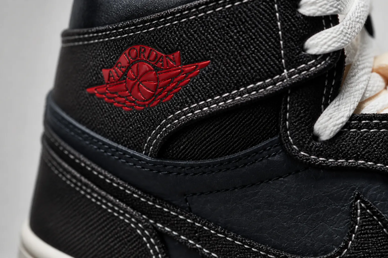 Close-up macro shot of the black woven textile upper showing intricate crosshatch pattern with subtle texture depth under studio lighting