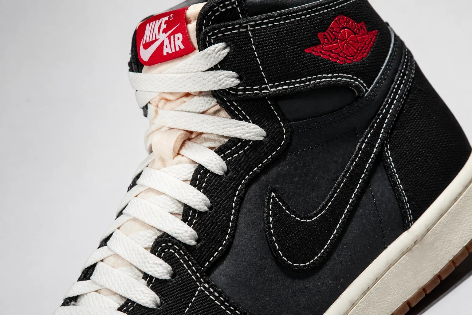 Dynamic product showcase of Air Jordan 1 Flight Club featuring premium black woven textile with dramatic lighting highlighting the University Red accent panels and iconic Jumpman branding