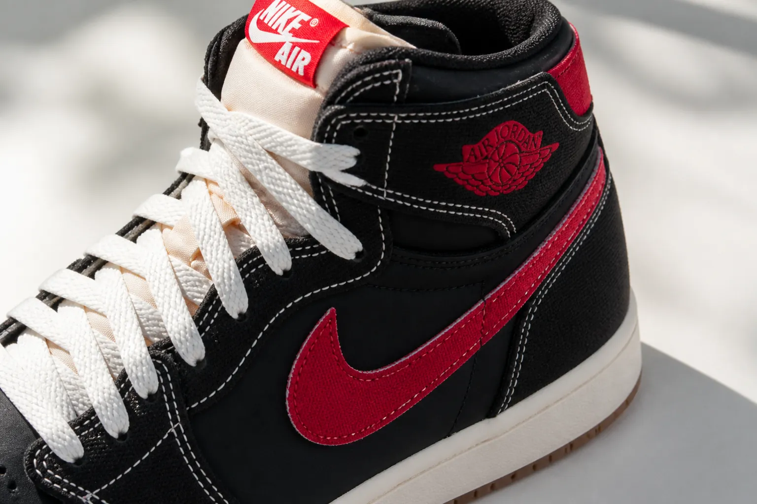 Air Jordan 1 Flight Club shoe highlighting University Red accents on swoosh logo and heel tab details